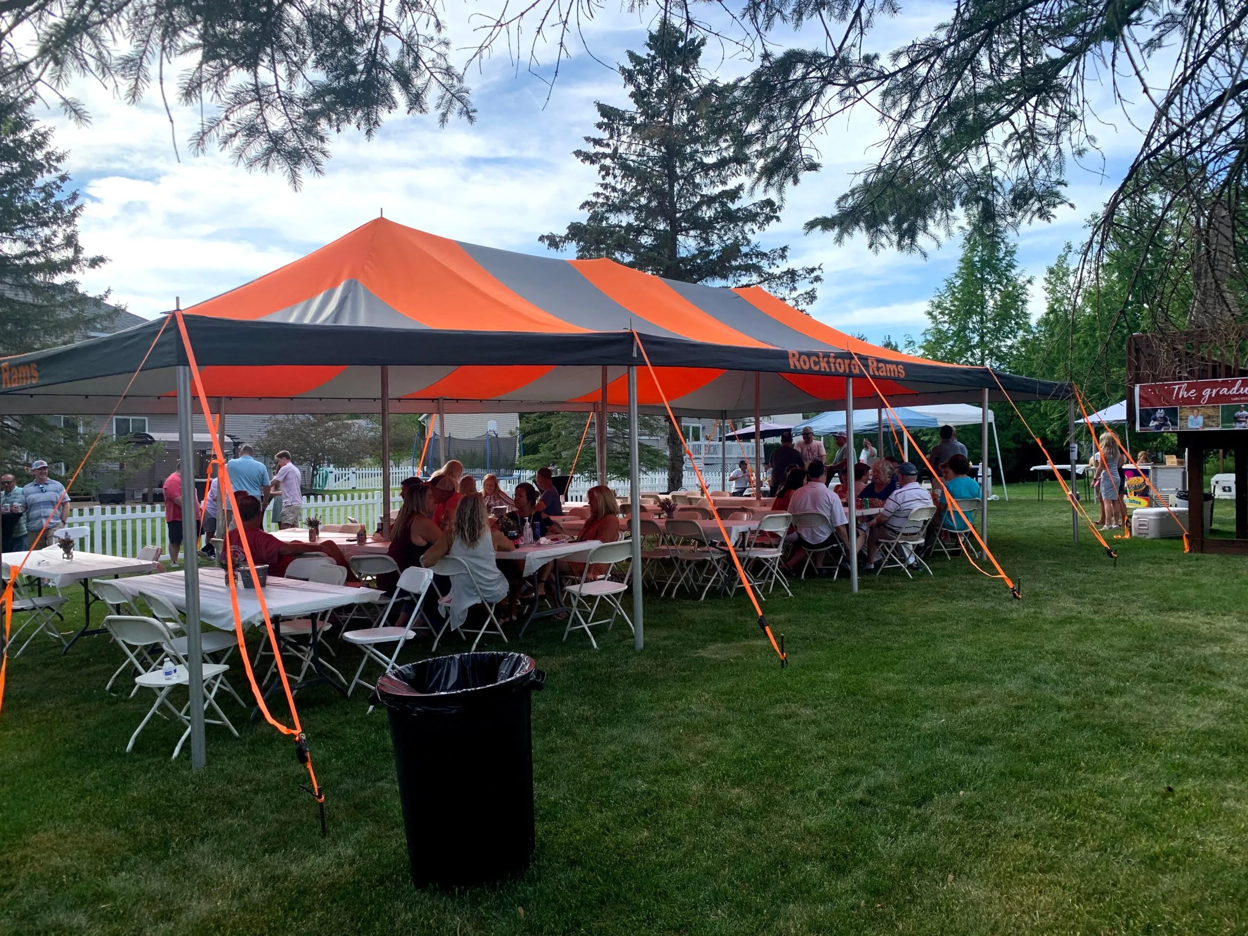 Guests dining under the orange and black tent